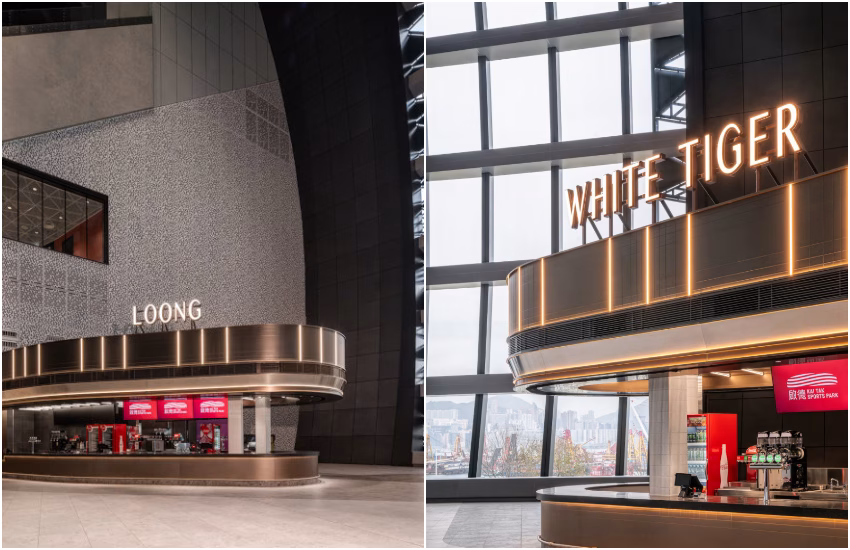 「Loong」 及 「White Tiger」位於三層南看台的左右兩側,背靠巨幅玻璃帷幕牆,飽覽維多利亞港的天際線。兩間運動酒吧以青銅色調象徵銅牌榮耀,將機場跑道指示燈系統昇華為空間燈光美學。頂部半透明樹脂板內嵌LED陣列,當左右兩邊酒吧燈光同時亮起,從南看台對面看檯面向維港,彷彿置身於飛機內,循著跑道燈光指引啟程。