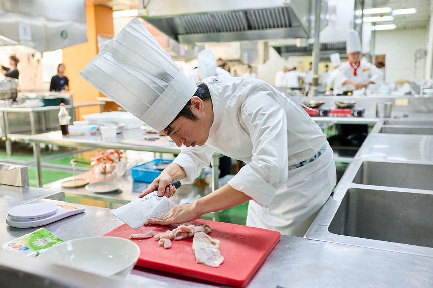 參賽業者全神貫注，以精湛刀工細心處理食材，展現職人料理的專業態度與廚藝功力。