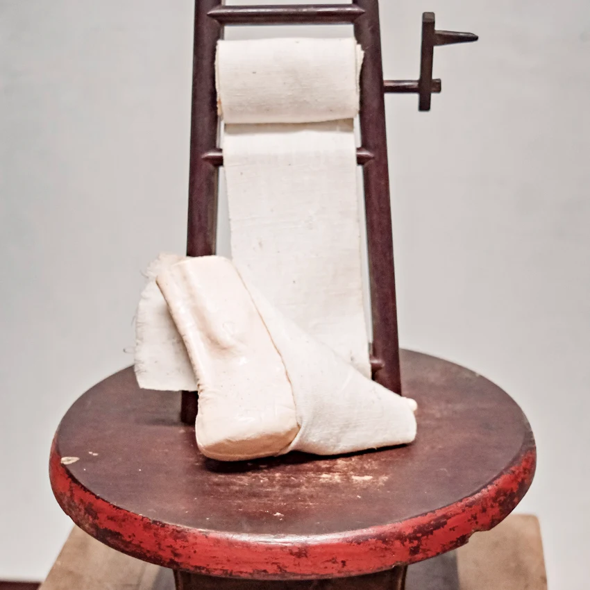 金蓮賞析(2) 裹腳布&輔助台：婦女躺在床上藉由輔助台來裹腳