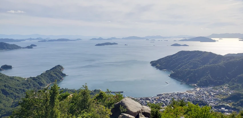 站在山頂的巨岩眺望開闊海景，令人心曠神怡。