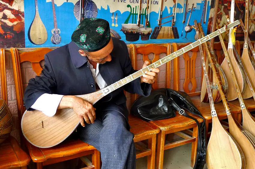 吾斯雄博依路被稱為職人巷，圖為老師正在彈奏傳統樂器「都塔爾」
