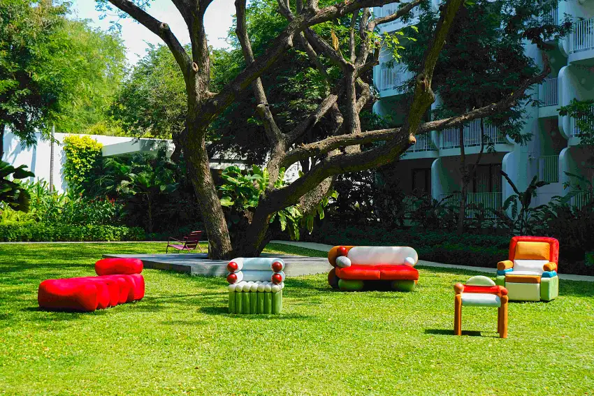 多件「The Puffiction」作品於綠意草地上錯落擺放，營造沉浸式戶外設計體驗。