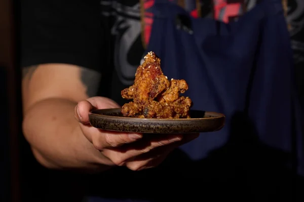 台灣首推新品「麻油醬燒雞翅」特別選用二節翅的中段部位,外皮包裹以麻油混合蒜汁的特製燒鳥醬汁。圖_inari Izakaya