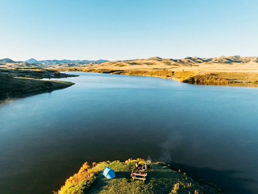 蒙大拿州遼闊荒野中的豪華露營（Glamping）場景。在「大天空之州」的丘陵與靜謐湖泊間，旅人能以最私密的方式深入自然，感受遠離塵囂的極致避世體驗。