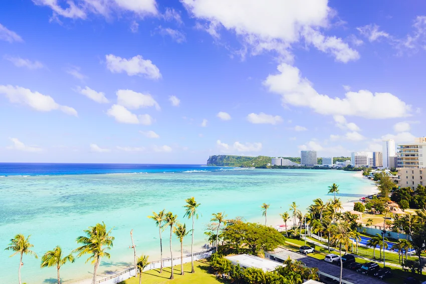 杜夢灣 (Tumon Bay) 提供了最優雅的度假節奏。這裡是珊瑚礁溫柔守護的天然內海，波浪平穩如鏡。您可以在半月形的白色沙灘上享受海風洗禮，隨後轉身投入緊鄰的免稅購物殿堂。