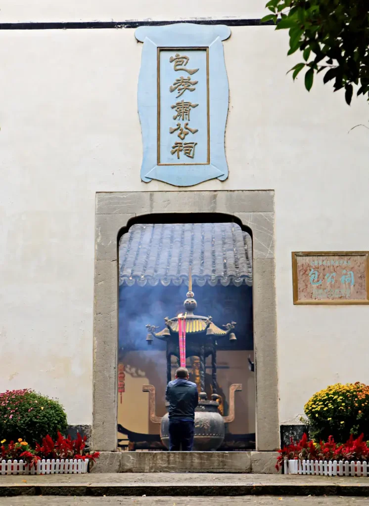 白牆黑瓦的包公祠外觀古樸莊嚴，祠堂內香火鼎盛